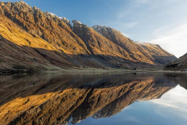 Loch Achtriochtan reflections in Glencoe with mountains lit by winter sunlight in the Scottish Highlands
