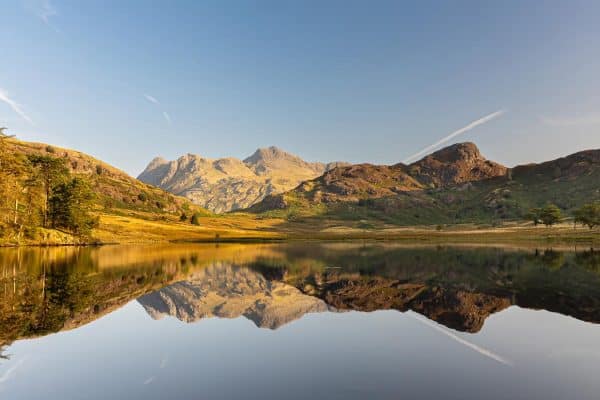Blea Tarn panoramic view towards the Langdale Pikes with mountain reflections in the Lake District
